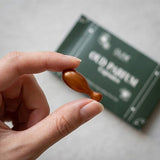 Oud Parfum Pod capsule held between fingers