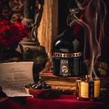 Oud bakhoor burning in a decorative bakhoor burner beside the fragrance jar